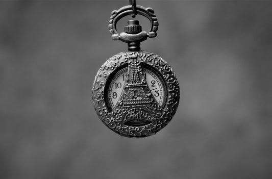 a black and white photo of a pocket watch